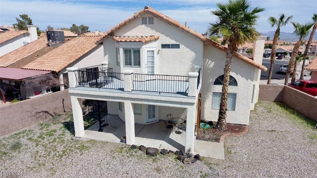 rear view of house featuring a patio and a balcony