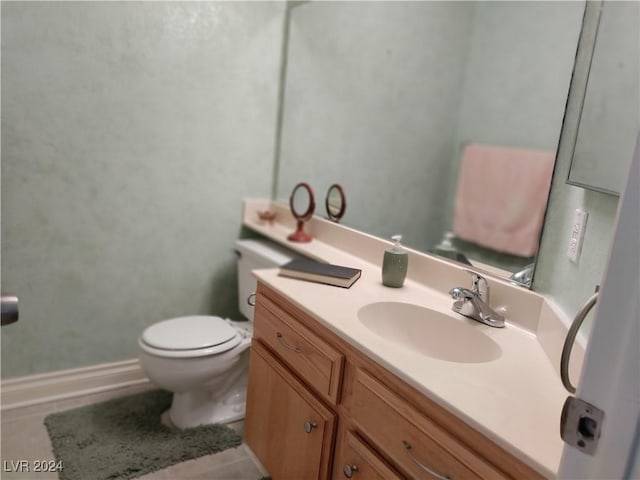 bathroom featuring tile patterned flooring, vanity, and toilet