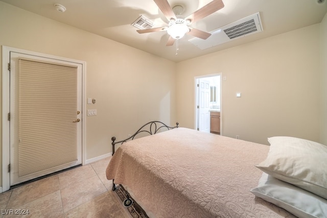 tiled bedroom featuring ensuite bath and ceiling fan