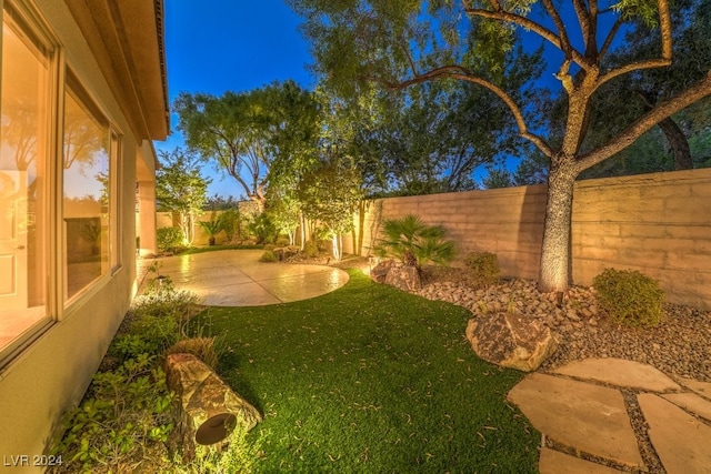 yard at dusk featuring a patio area