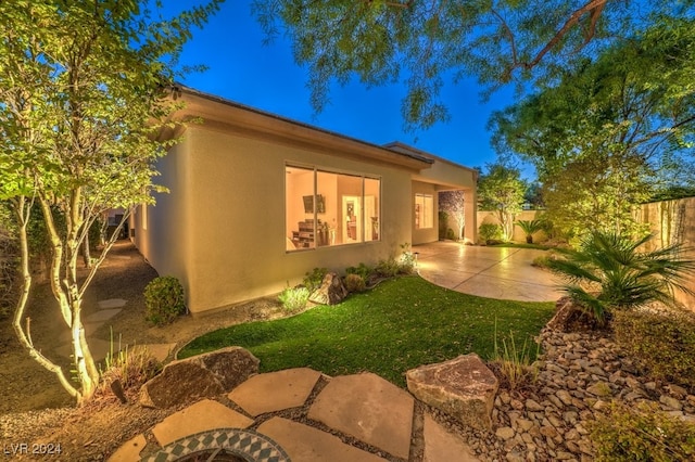 view of property exterior featuring a lawn and a patio area