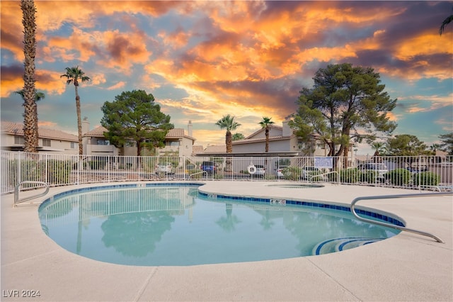 pool at dusk featuring a patio