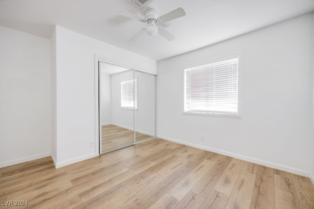 unfurnished bedroom with ceiling fan, a closet, and light wood-type flooring