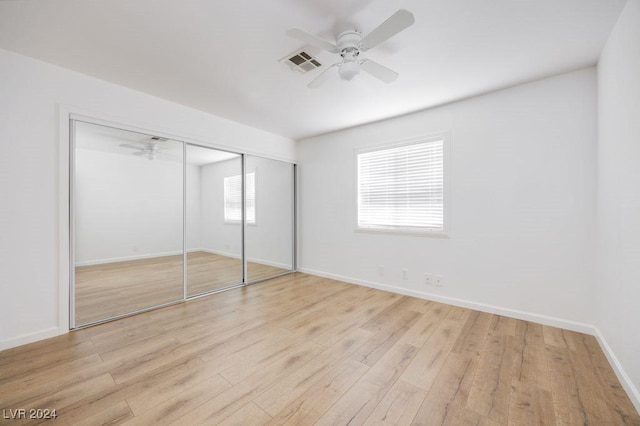 unfurnished bedroom featuring ceiling fan, light hardwood / wood-style flooring, and a closet