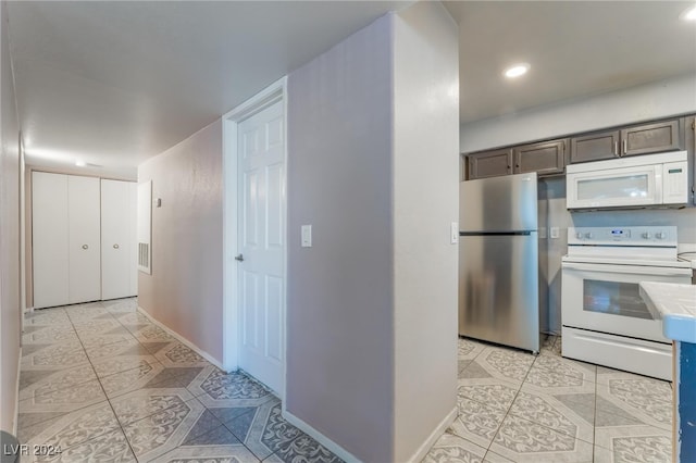 kitchen featuring dark brown cabinetry, tile countertops, and white appliances