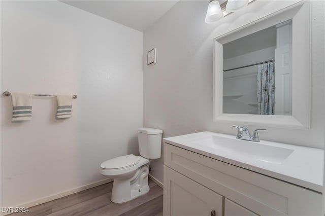 bathroom featuring wood-type flooring, vanity, and toilet