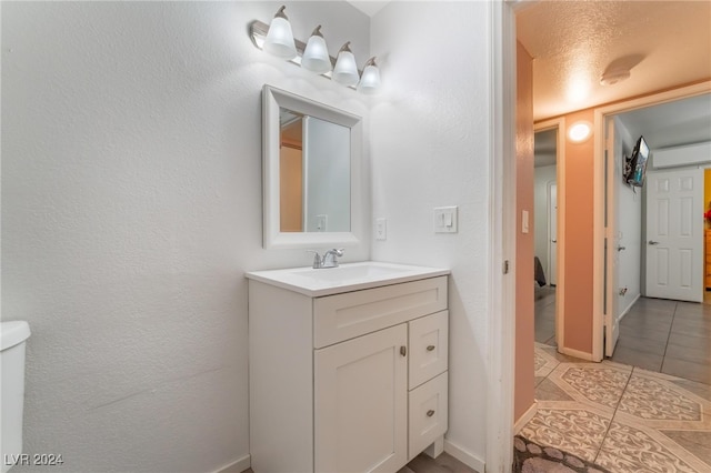 bathroom with tile patterned floors, a textured ceiling, and vanity