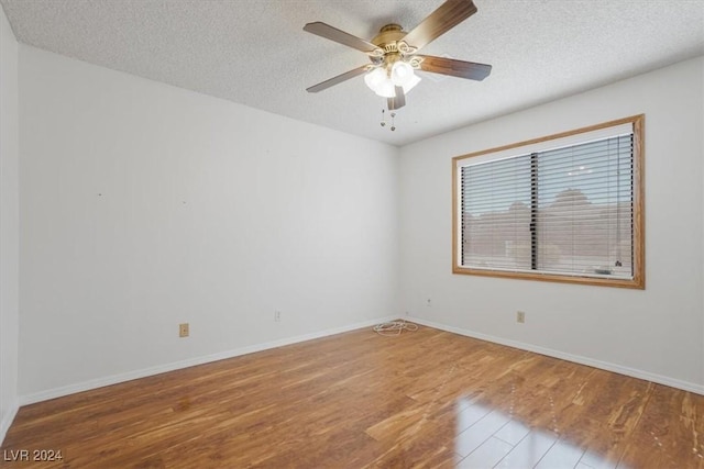 empty room featuring ceiling fan, wood-type flooring, and a textured ceiling