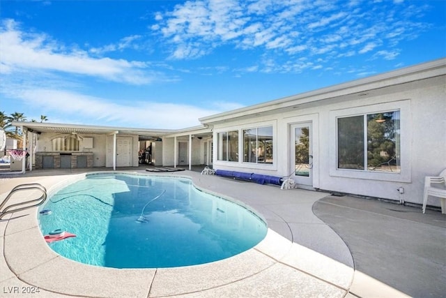 view of swimming pool featuring a patio area and exterior bar