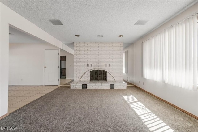 unfurnished living room featuring a fireplace, a textured ceiling, and light colored carpet