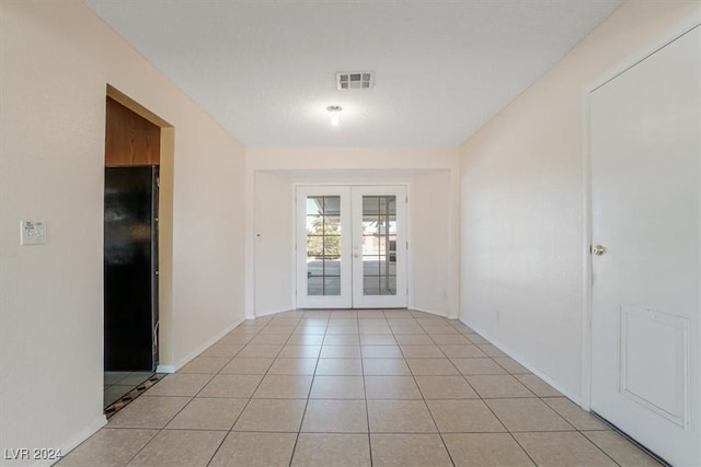 doorway featuring light tile patterned flooring and french doors