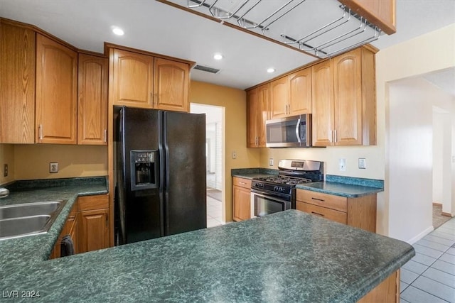 kitchen with light tile patterned floors, sink, and stainless steel appliances