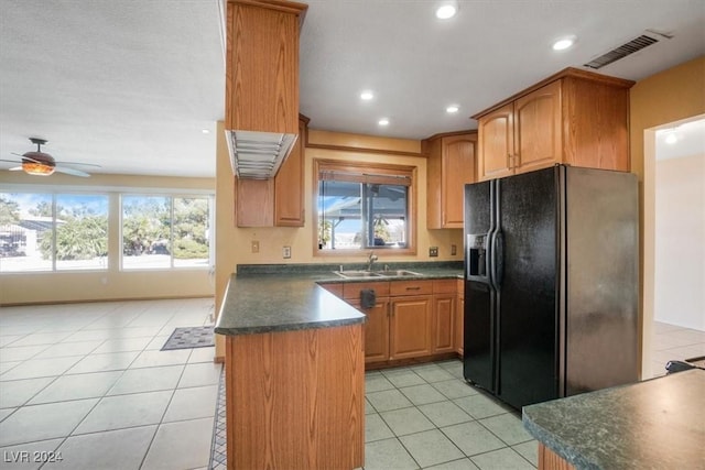 kitchen featuring light tile patterned flooring, ceiling fan, sink, and black fridge with ice dispenser