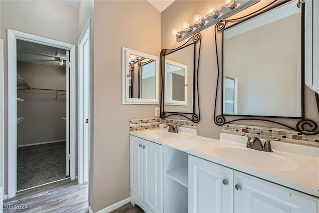 bathroom featuring decorative backsplash, hardwood / wood-style flooring, and vanity