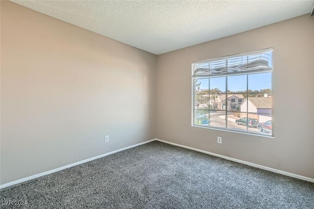 carpeted spare room featuring a textured ceiling