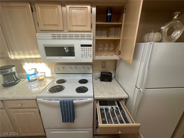 kitchen featuring white appliances and light brown cabinets