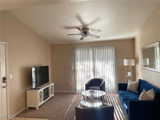 living room with ceiling fan, carpet flooring, and a textured ceiling