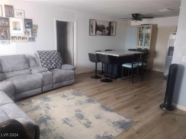 living room featuring hardwood / wood-style floors and ceiling fan