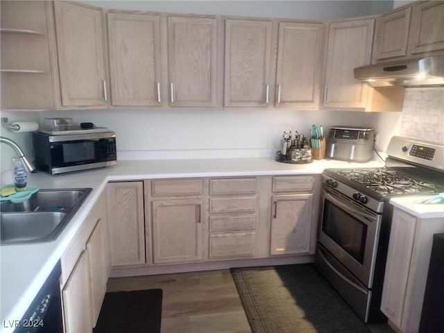 kitchen with hardwood / wood-style flooring, tasteful backsplash, sink, stainless steel appliances, and light brown cabinetry