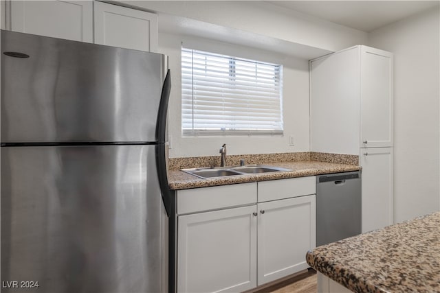 kitchen featuring white cabinets, stainless steel appliances, sink, and light hardwood / wood-style flooring