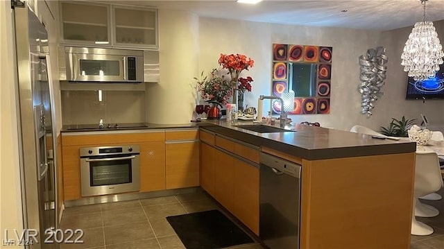 kitchen with an inviting chandelier, kitchen peninsula, sink, and stainless steel appliances