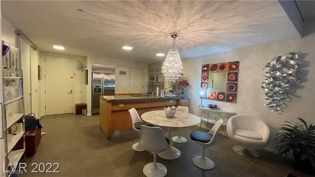 dining area featuring a notable chandelier and dark tile patterned floors