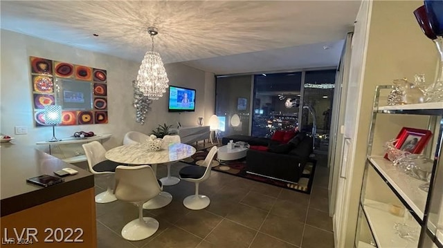 dining area featuring an inviting chandelier and dark tile patterned flooring