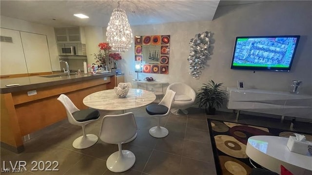 tiled dining area featuring an inviting chandelier and sink