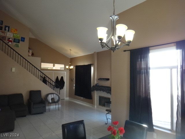 tiled living room featuring lofted ceiling and a notable chandelier