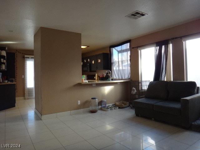 living room featuring a wealth of natural light and light tile patterned floors