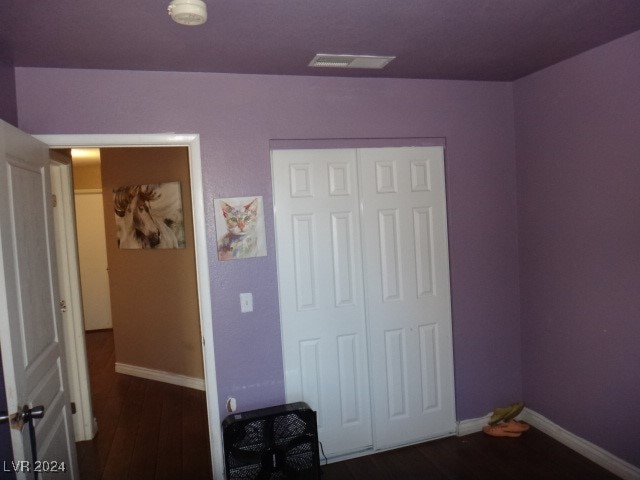 bedroom featuring a closet and dark wood-type flooring