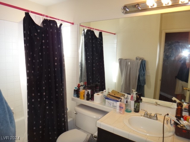 full bathroom featuring shower / bath combo with shower curtain, vanity, and toilet