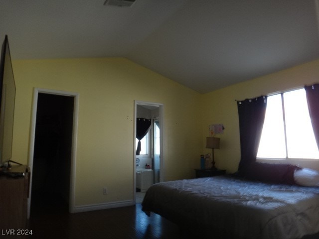 bedroom with wood-type flooring, ensuite bath, and vaulted ceiling