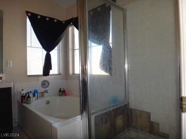 bathroom featuring separate shower and tub