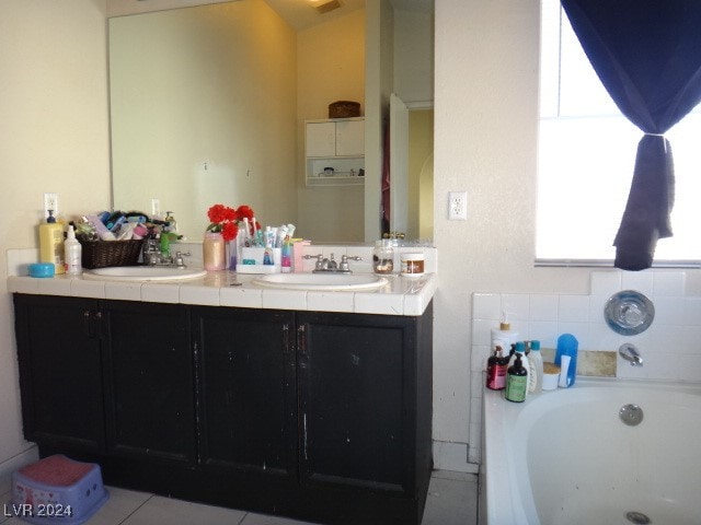 bathroom with a tub to relax in, tile patterned flooring, and vanity