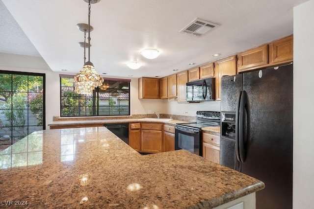 kitchen with kitchen peninsula, decorative light fixtures, light stone countertops, and black appliances