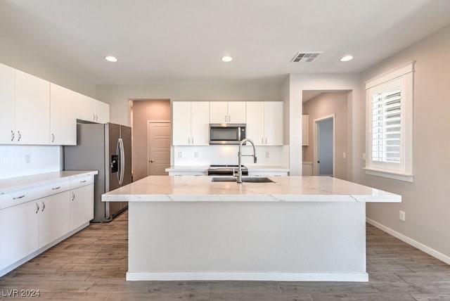 kitchen with a center island with sink, white cabinetry, sink, and stainless steel appliances