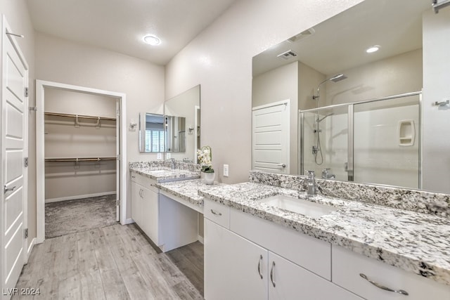 bathroom featuring hardwood / wood-style flooring, vanity, and an enclosed shower