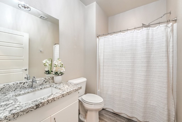 bathroom with wood-type flooring, a shower with curtain, vanity, and toilet