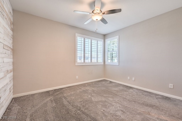 carpeted spare room with ceiling fan