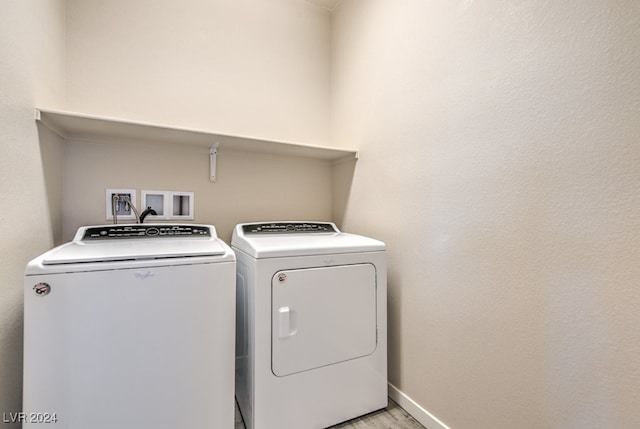 washroom featuring light wood-type flooring and separate washer and dryer