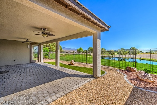 view of patio / terrace featuring ceiling fan and a water view