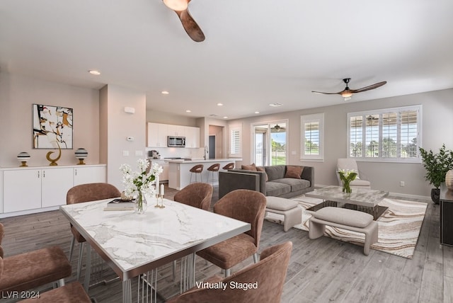 dining area with ceiling fan and light hardwood / wood-style flooring