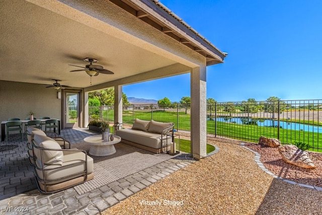 view of patio featuring an outdoor hangout area, a water view, and ceiling fan