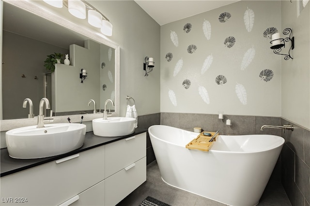 bathroom with vanity, a bathing tub, tile walls, and tile patterned floors