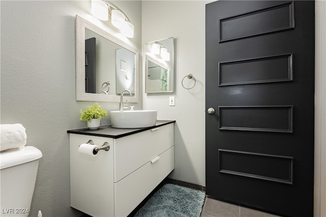 bathroom featuring tile patterned flooring, vanity, and toilet