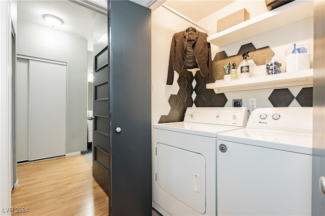 laundry room with light hardwood / wood-style floors and washing machine and dryer