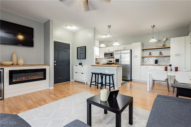 living room featuring light wood-type flooring and ceiling fan