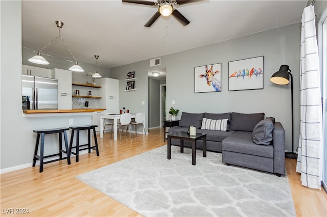 living room featuring light wood-type flooring and ceiling fan