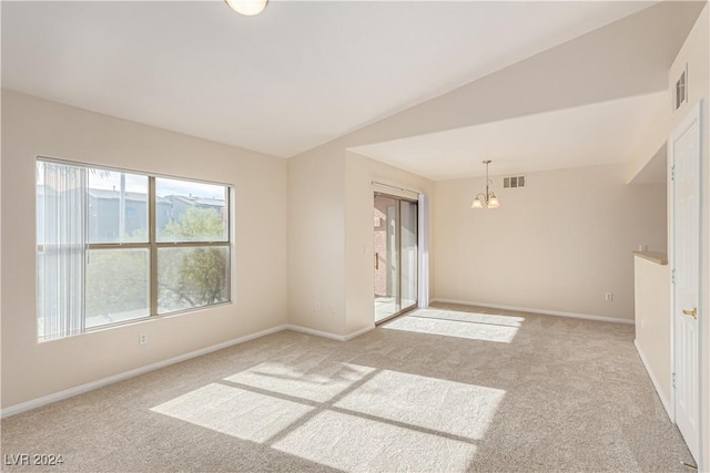 carpeted spare room with a chandelier and lofted ceiling